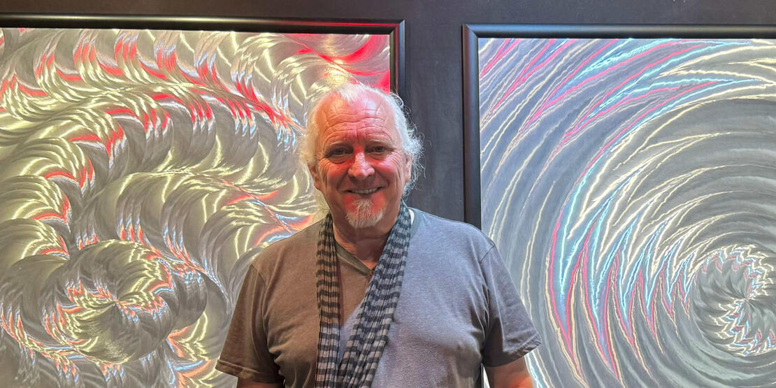 Photo of artist with illusionary art pieces